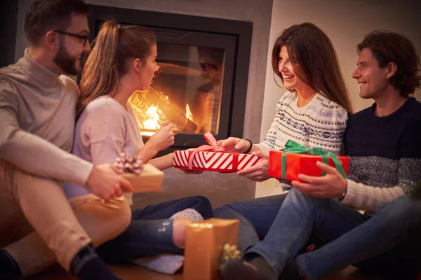 Grupo de amigos con regalos celebrando la Navidad en casa — Foto de Stock