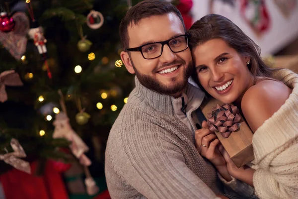 Casal adulto com presente sobre a árvore de Natal — Fotografia de Stock