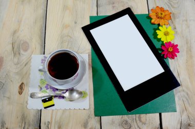 Güzel bir fincan buzlu çay yıpranmış ahşaptan yapılmış bir masanın üzerine konur, masanın üzerinde bir çay kaşığı ve bir peçete vardır..