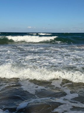 Dalgalar ve su sıçrıyor kumlu bir sahilde