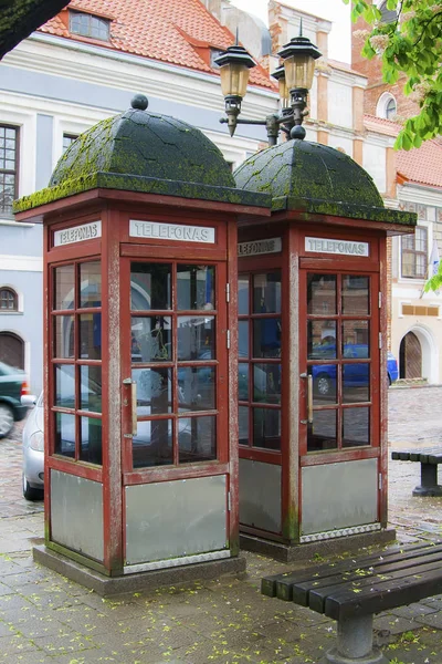 在阴云密布的天气里 考纳斯街屋顶上有两个有苔藓的电话亭 — 图库照片