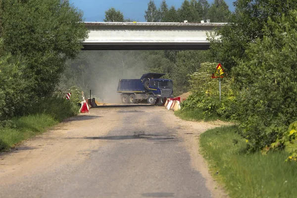 Caminhão de descarga azul contra um fundo de árvores — Fotografia de Stock