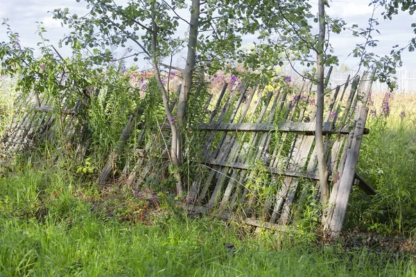 Opadający płot składający się z pionowych drewnianych liczek — Zdjęcie stockowe