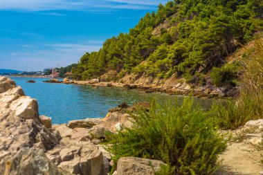 Hırvatistan 'ın Split kenti yakınlarındaki aşırı gelişmiş kayalık yamaçlarla aydınlık güneşli bir öğleden sonra, denizin kıyı şeridi