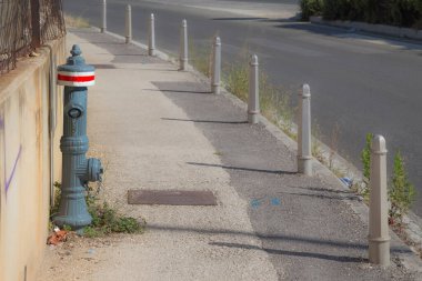 Hırvatistan - beton döşemeye karşı parlak kırmızı çizgili gri bir yangın musluğu