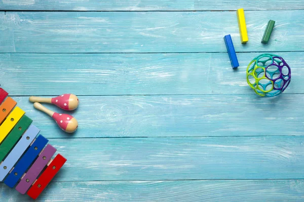 Colorato bambini giocattoli cornice su sfondo di legno. Vista dall'alto. Piatto. Copia spazio per testo . — Foto Stock