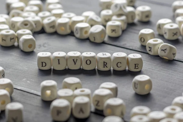 Parola - Divorzio composto da lettere in legno sul tavolo con fedi nuziali . — Foto Stock