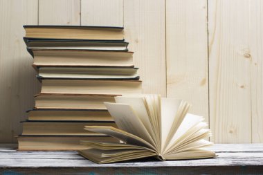 Açık kitap, ahşap masadaki ciltli kitaplar. Okula dönelim. Boşluğu kopyala