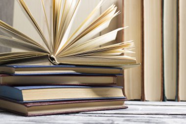 Açık kitap, ahşap masadaki ciltli kitaplar. Okula dönelim. Boşluğu kopyala