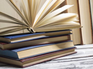 Açık kitap, ahşap masadaki ciltli kitaplar. Okula dönelim. Boşluğu kopyala