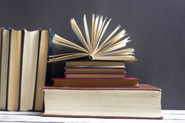 Açık kitap, ahşap masadaki ciltli kitaplar. Okula dönelim. Boşluğu kopyala
