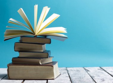 Açık kitap, ahşap masadaki ciltli kitaplar. Okula dönelim. Boşluğu kopyala