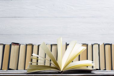 Açık kitap, ahşap masadaki ciltli kitaplar. Okula dönelim. Boşluğu kopyala