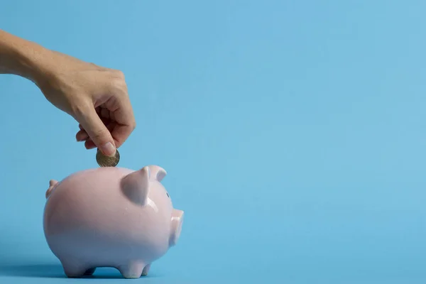 Vrouw hand zetten geld munt in piggy voor het besparen van geld rijkdom en financieel concept — Stockfoto