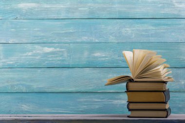 Açık kitap, ahşap masadaki ciltli kitaplar. Okula dönelim. Boşluğu kopyala
