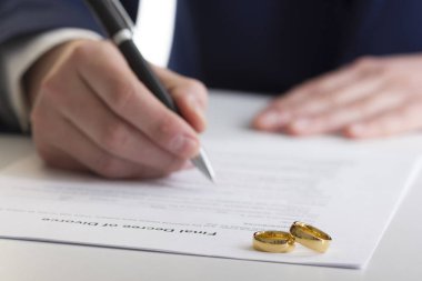 Boşanma konsepti. Eşinin elleri, boşanma kararı imzalama, evliliğin iptali, yasal ayrılık belgeleri.