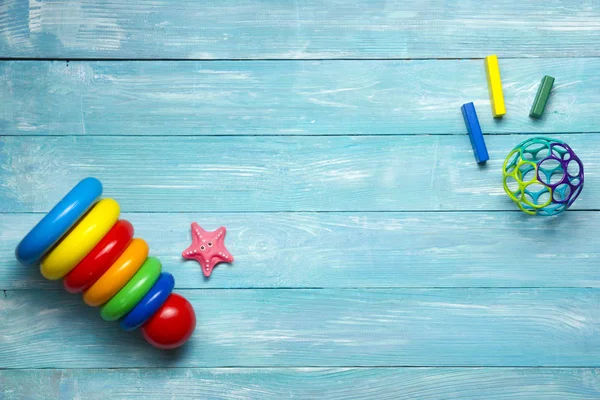 Marco colorido de los juguetes de los niños en fondo de madera. Vista superior. Acostado. Copiar espacio para texto . — Foto de Stock