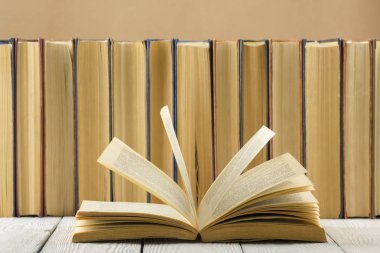 Açık kitap, ahşap masadaki ciltli kitaplar. Okula dönelim. Boşluğu kopyala