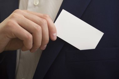 Beyaz arka plan üzerinde beyaz kartvizit tutan el.