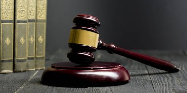 Hukuk kavramı - Bir mahkeme veya kolluk ofisinde masada ahşap bir hakim tokmak ile açık hukuk kitabı