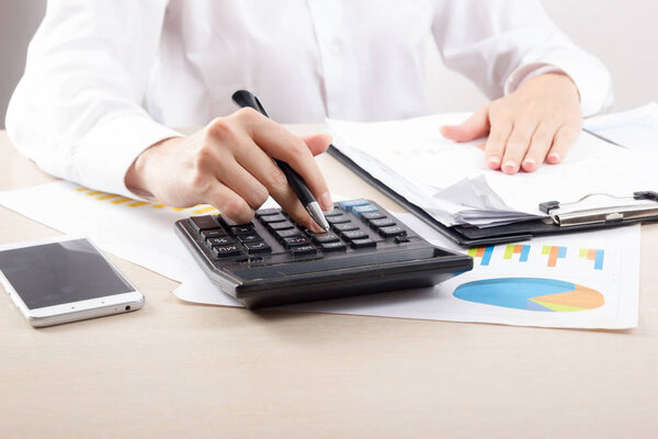 Крупным планом женщина-бухгалтер или банкир делает расчеты. Экономия, финансы и концепция экономики
