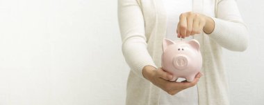 Kadın, para biriktirmek ve finansal konsept için domuzcuğa para yatırıyor.