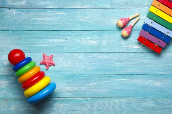 Marco colorido de los juguetes de los niños en fondo de madera. Vista superior. Acostado. Copiar espacio para texto . — Foto de Stock