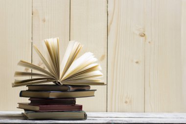 Açık kitap, ahşap masadaki ciltli kitaplar. Okula dönelim. Boşluğu kopyala