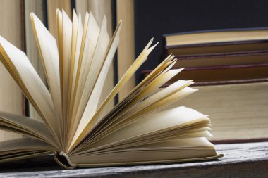 Açık kitap, ahşap masadaki ciltli kitaplar. Okula dönelim. Boşluğu kopyala