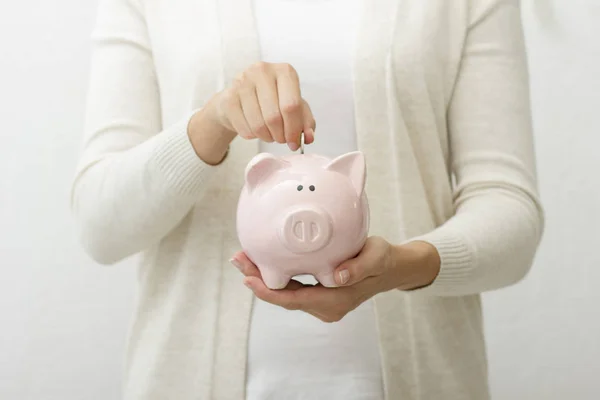 Γυναίκα χέρι βάζοντας χρήματα νόμισμα σε piggy για την εξοικονόμηση πλούτου χρήματα και την οικονομική έννοια. — Φωτογραφία Αρχείου