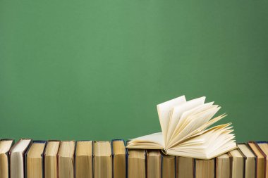 Açık kitap, ahşap masadaki ciltli kitaplar. Okula dönelim. Boşluğu kopyala
