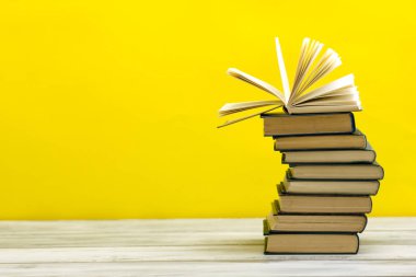 Açık kitap, ahşap masadaki ciltli kitaplar. Okula dönelim. Boşluğu kopyala.