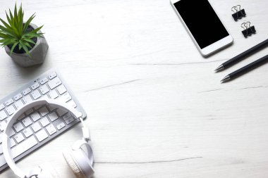 Bilgisayarlı beyaz masa ofisi, akıllı telefon ve bir fincan kahveli diğer iş malzemeleri. Metni kopyalamak için üst görünümü kullan. Desenci çalışma alanı düz masa üzerinde temel elementler yatıyordu