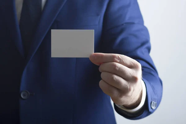 Mano sosteniendo tarjeta de visita blanca sobre fondo blanco — Foto de Stock