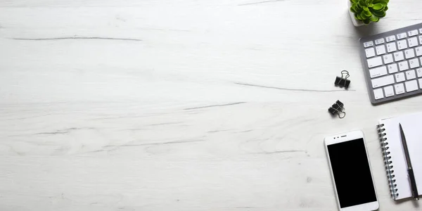Bilgisayarlı beyaz masa ofisi, akıllı telefon ve bir fincan kahveli diğer iş malzemeleri. Metni kopyalamak için üst görünümü kullan. Desenci çalışma alanı düz masa üzerinde temel elementler yatıyordu