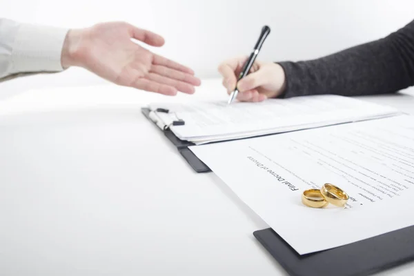 Χέρια συζύγου, συζύγου που υπογράφει διάταγμα διαζυγίου, διάλυσης, ακύρωσης γάμου, νομικών εγγράφων χωρισμού, κατάθεσης εγγράφων διαζυγίου ή προγαμιαίου συμβολαίου που εκπονείται από δικηγόρο. Βέρα γάμου — Φωτογραφία Αρχείου