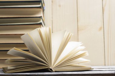 Açık kitap, ahşap masadaki ciltli kitaplar. Okula dönelim. Boşluğu kopyala