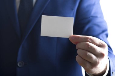 Beyaz arka plan üzerinde beyaz kartvizit tutan el
