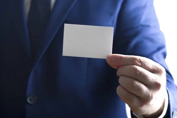 Mano sosteniendo tarjeta de visita blanca sobre fondo blanco — Foto de Stock