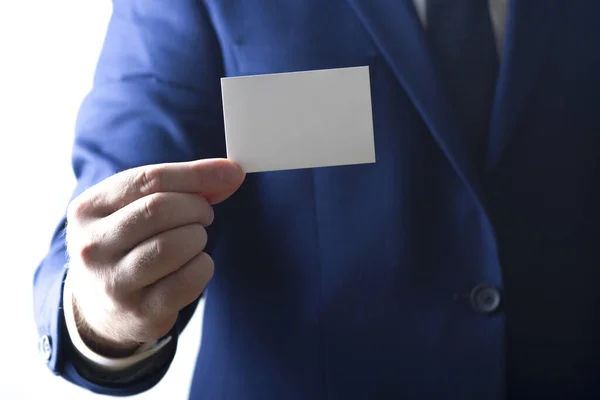 Mano sosteniendo tarjeta de visita blanca sobre fondo blanco — Foto de Stock