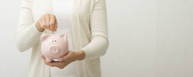 Kadın, para biriktirmek ve finansal konsept için domuzcuğa para yatırıyor..