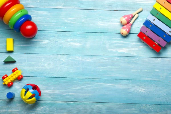 Cadre de jouets colorés pour enfants sur fond en bois. Vue de dessus. Pose plate. Espace de copie pour le texte . — Photo