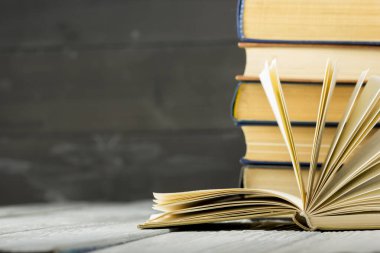 Açık kitap, ahşap masadaki ciltli kitaplar. Okula dönelim. Boşluğu kopyala