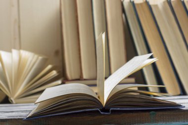 Açık kitap, ahşap masadaki ciltli kitaplar. Okula dönelim. Boşluğu kopyala