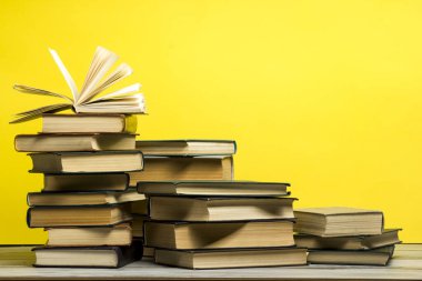 Açık kitap, ahşap masadaki ciltli kitaplar. Okula dönelim. Boşluğu kopyala.