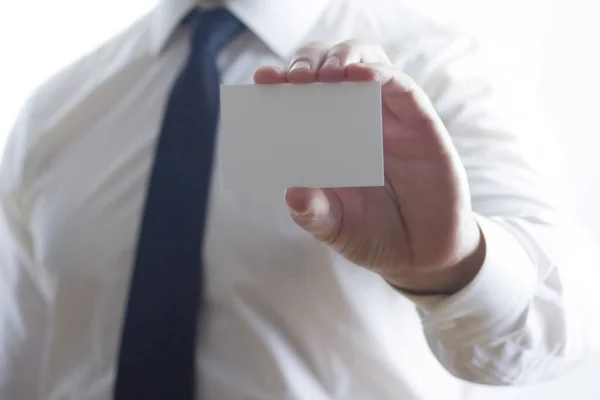 Mão segurando cartão de visita branco no fundo branco — Fotografia de Stock