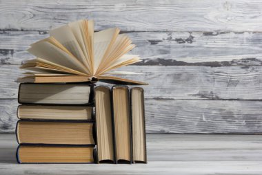 Açık kitap, ahşap masadaki ciltli kitaplar. Okula dönelim. Boşluğu kopyala