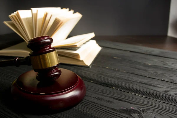 Law concept - Open law book with a wooden judges gavel on table in a courtroom or law enforcement office isolated on white background. Copy space for text