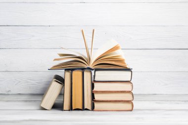 Açık kitap, ahşap masadaki ciltli kitaplar. Okula dönelim. Boşluğu kopyala