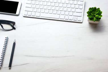 Bilgisayarlı beyaz masa ofisi, akıllı telefon ve bir fincan kahveli diğer iş malzemeleri. Metni kopyalamak için üst görünümü kullan. Desenci çalışma alanı düz masa üzerinde temel elementler yatıyordu